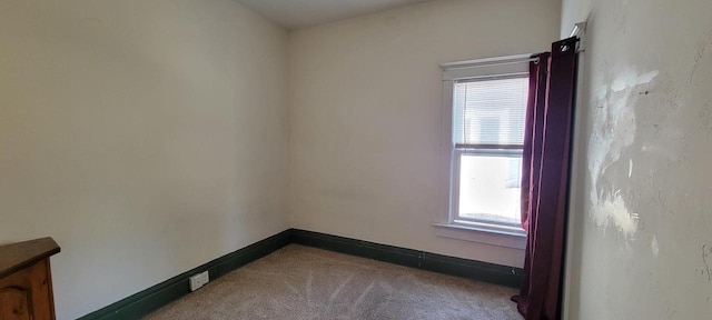 unfurnished room featuring carpet and baseboards