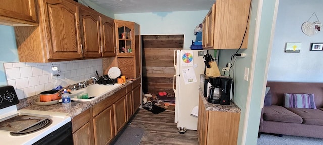 kitchen featuring brown cabinets, electric stove, a sink, freestanding refrigerator, and decorative backsplash