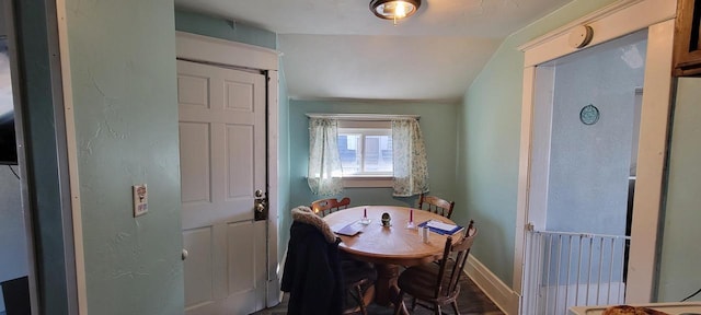 dining area with baseboards and vaulted ceiling