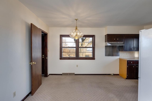 unfurnished dining area with a chandelier, visible vents, and baseboards