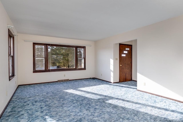 spare room with baseboards, carpet floors, and visible vents