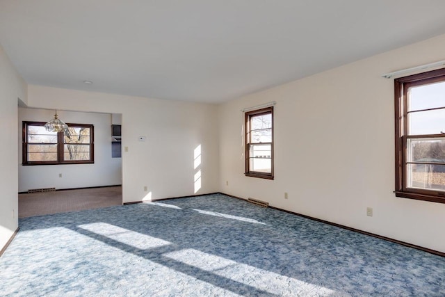 empty room featuring visible vents, baseboards, and carpet floors