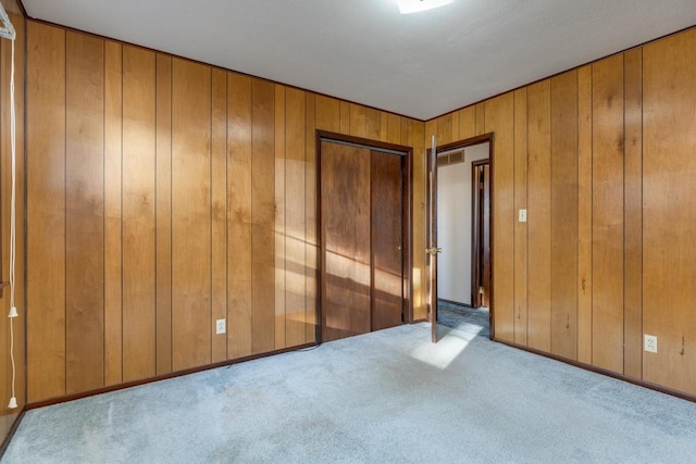 unfurnished bedroom with carpet floors and wood walls