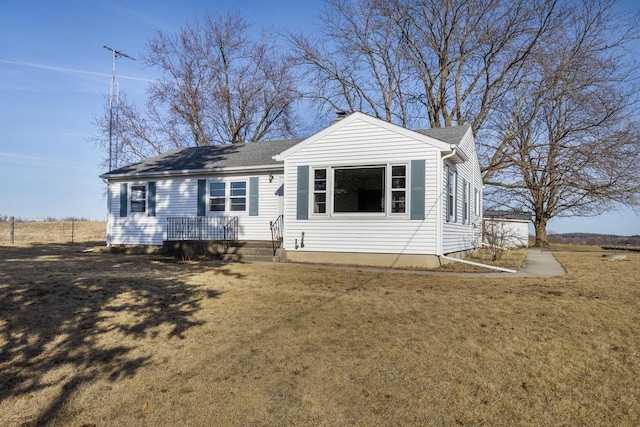 view of front of property with a front lawn and roof with shingles