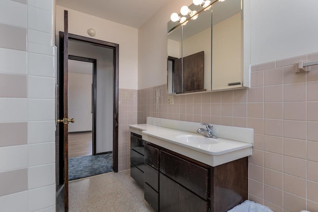 bathroom with a wainscoted wall, tile walls, and vanity