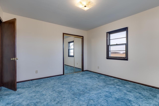 carpeted spare room featuring baseboards