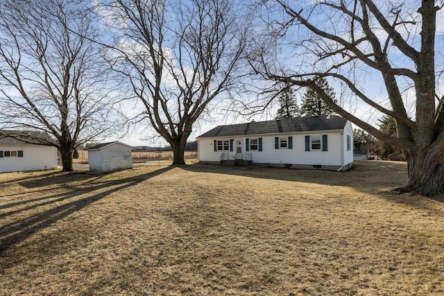 view of front of house with a storage shed and an outbuilding