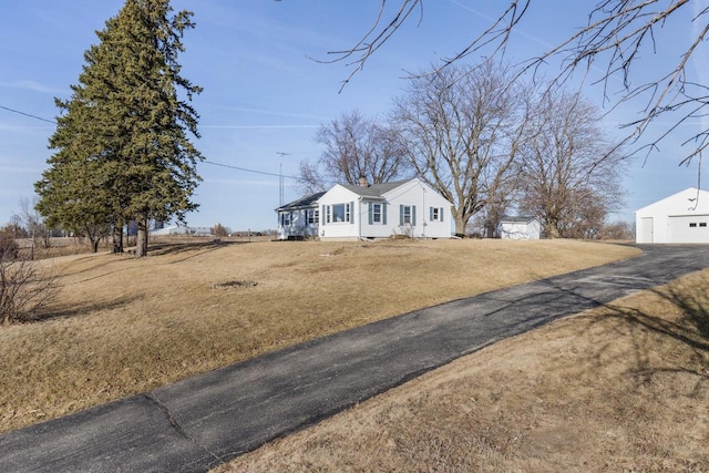 view of front of house with a front lawn and an outbuilding