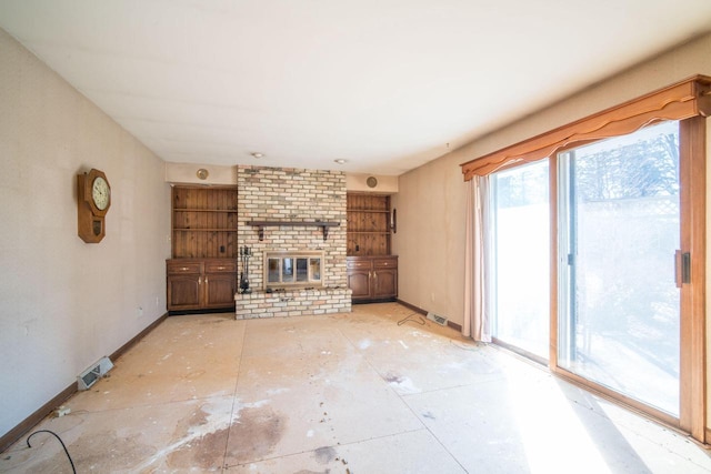 unfurnished living room featuring visible vents, baseboards, and a brick fireplace