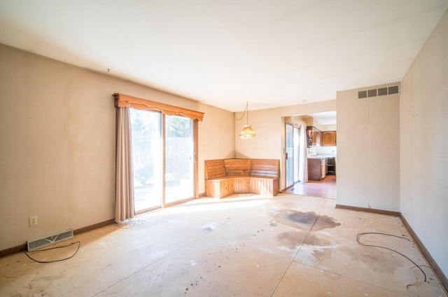 unfurnished living room featuring visible vents and baseboards