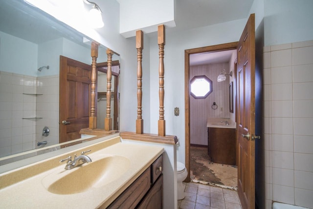 full bath featuring toilet, vanity, and tile patterned flooring