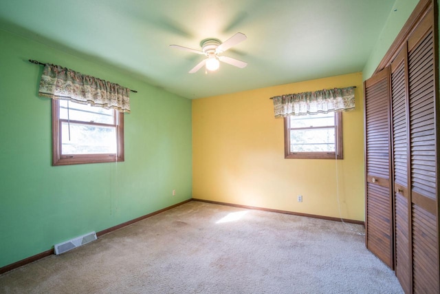 unfurnished bedroom with multiple windows, visible vents, a closet, and carpet floors