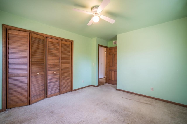 unfurnished bedroom with visible vents, light carpet, a ceiling fan, a closet, and baseboards