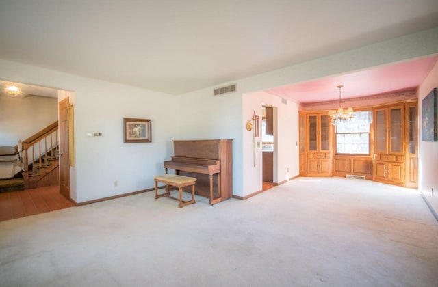 interior space with visible vents, baseboards, carpet, and an inviting chandelier