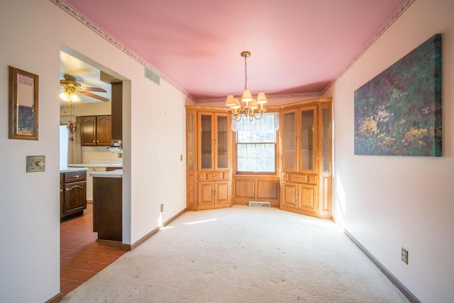 unfurnished dining area featuring visible vents, baseboards, light colored carpet, and ornamental molding