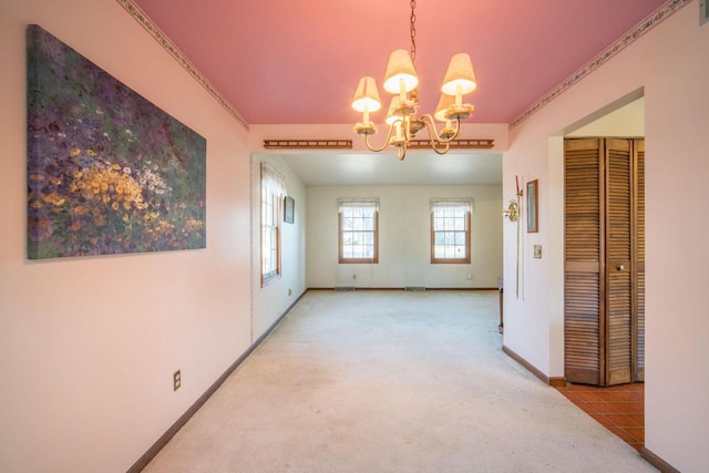 carpeted empty room featuring an inviting chandelier, visible vents, and baseboards