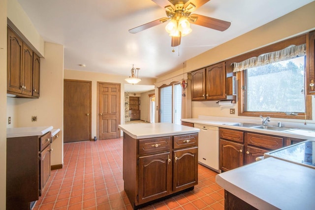 kitchen with a center island, dishwasher, light countertops, a ceiling fan, and a sink