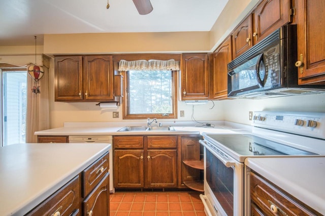 kitchen with a sink, light countertops, black microwave, and electric stove