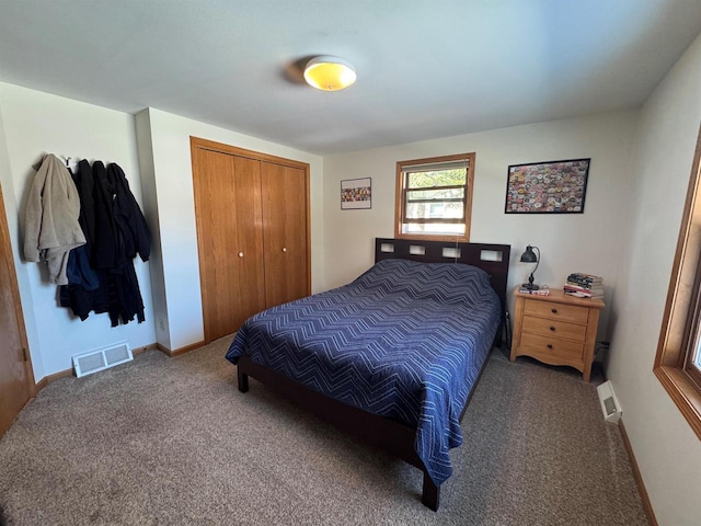 carpeted bedroom with a closet, visible vents, and baseboards