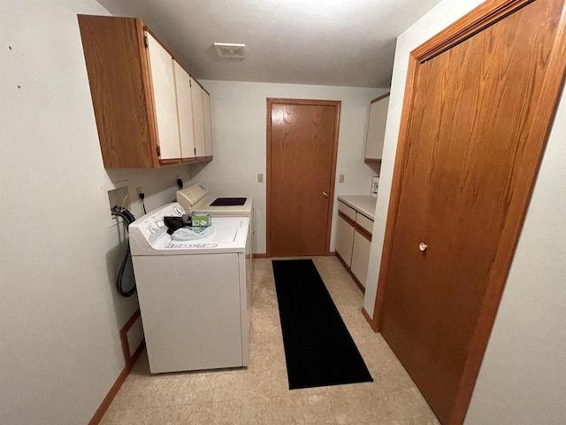 clothes washing area with visible vents, cabinet space, separate washer and dryer, baseboards, and light floors