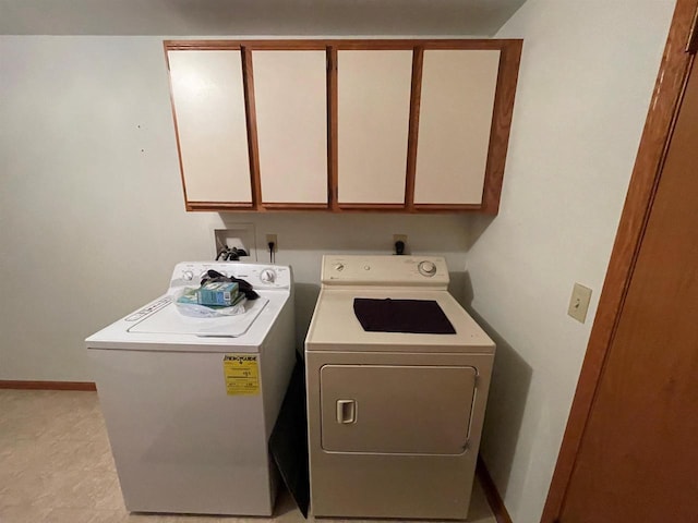 laundry room with washer and dryer, baseboards, and cabinet space