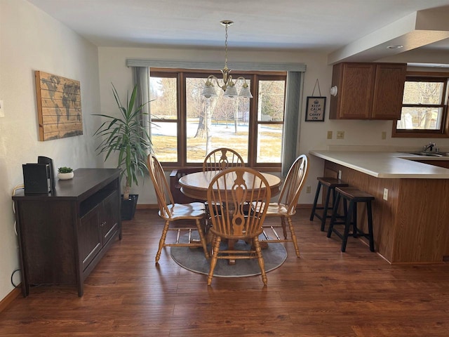 dining room with baseboards, a notable chandelier, and dark wood-style floors