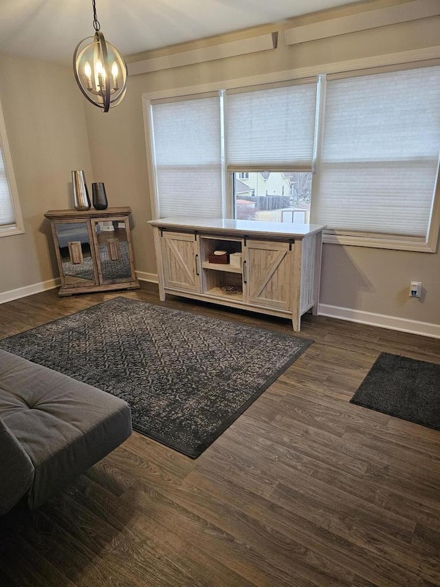 sitting room featuring dark wood finished floors, a notable chandelier, and baseboards