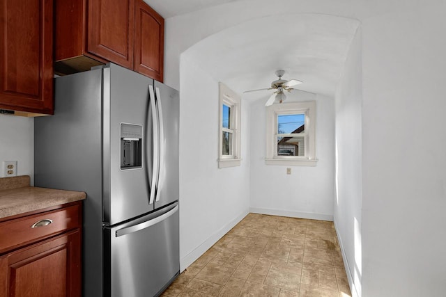 kitchen featuring light countertops, a ceiling fan, stainless steel refrigerator with ice dispenser, and baseboards