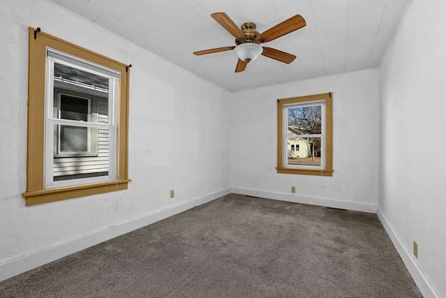 unfurnished room with carpet flooring, a ceiling fan, and baseboards