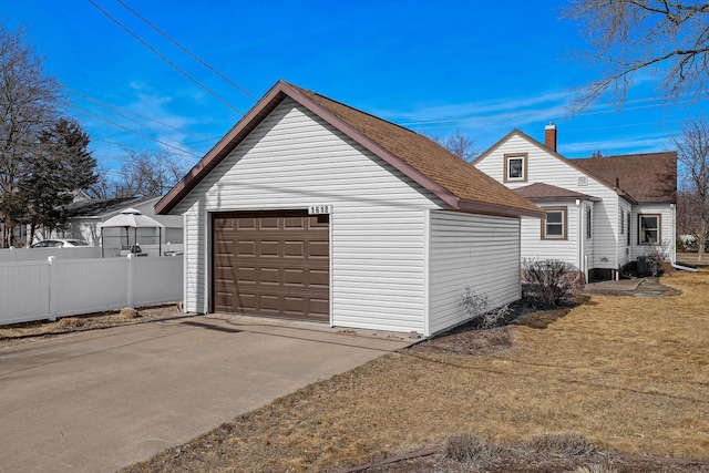 detached garage featuring fence