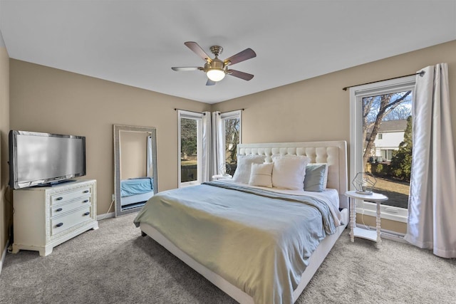 bedroom featuring baseboards, light colored carpet, and ceiling fan