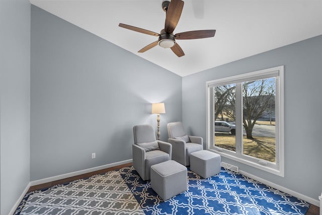 sitting room with baseboards, lofted ceiling, visible vents, and a ceiling fan