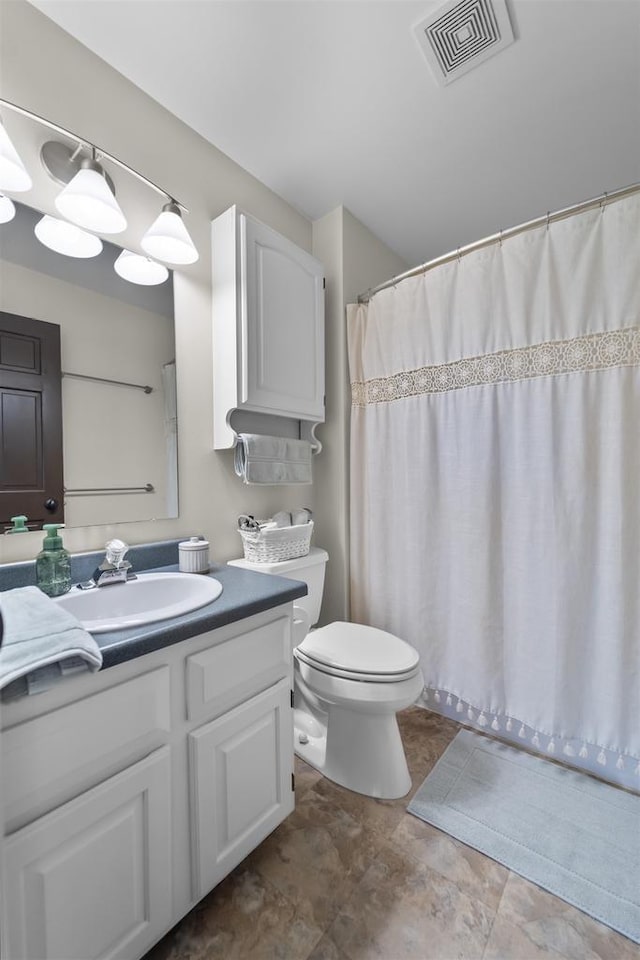 full bathroom with vanity, a shower with shower curtain, toilet, and visible vents