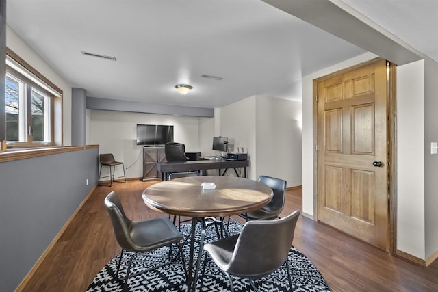 dining room featuring visible vents, baseboards, and wood finished floors