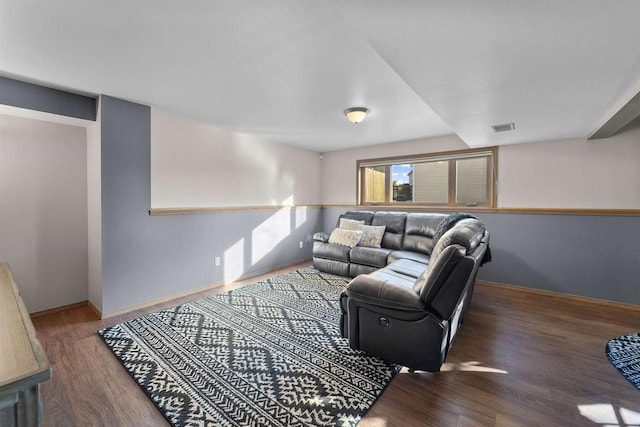 living area featuring wood finished floors, visible vents, and baseboards