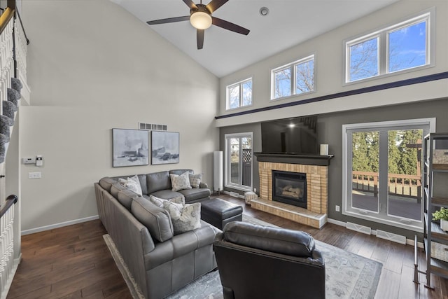 living area with a fireplace, high vaulted ceiling, ceiling fan, and wood-type flooring