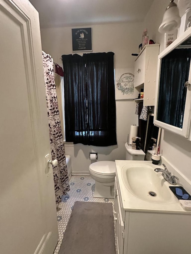 bathroom featuring tile patterned floors, toilet, shower / bath combo, and vanity