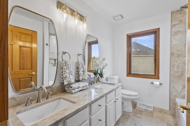 full bathroom with double vanity, toilet, baseboards, and a sink