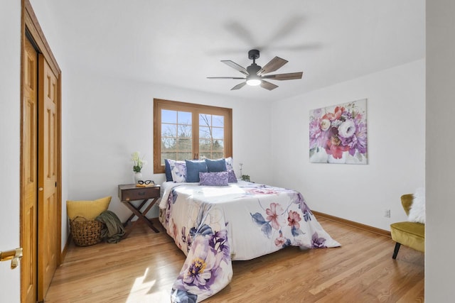 bedroom with a ceiling fan, light wood-style floors, a closet, and baseboards