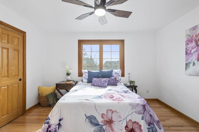 bedroom with light wood-type flooring, baseboards, and a ceiling fan