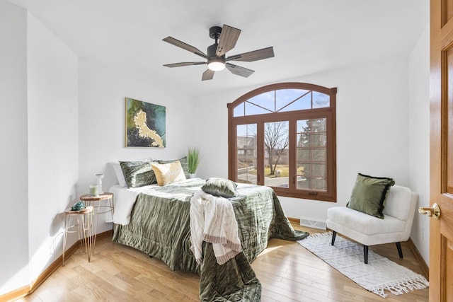 bedroom featuring light wood-style flooring, a ceiling fan, and baseboards