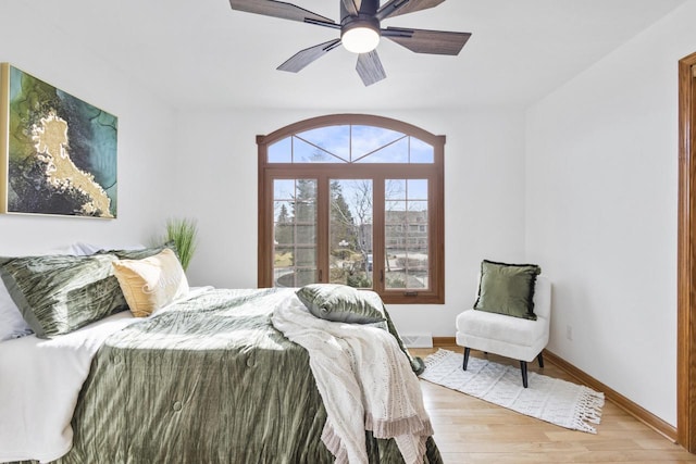 bedroom featuring baseboards, light wood-style floors, and a ceiling fan