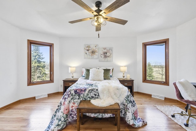 bedroom featuring visible vents, baseboards, and wood finished floors