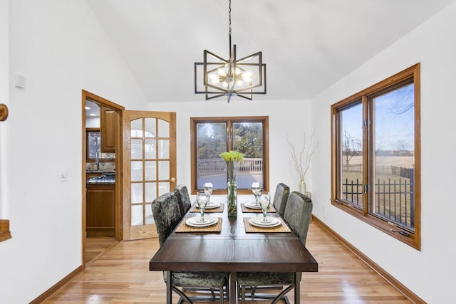 dining room featuring a notable chandelier, baseboards, and light wood-style floors