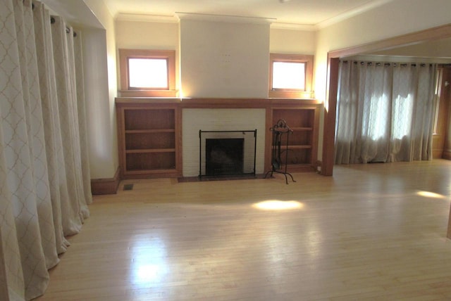 unfurnished living room with a fireplace, wood finished floors, and ornamental molding