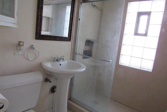 bathroom featuring toilet and walk in shower