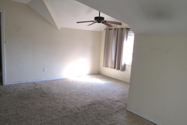 empty room with baseboards, carpet, a ceiling fan, and vaulted ceiling