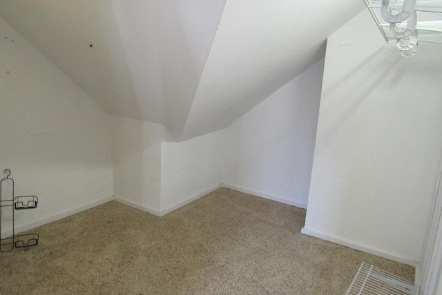 additional living space with baseboards, lofted ceiling, and carpet flooring