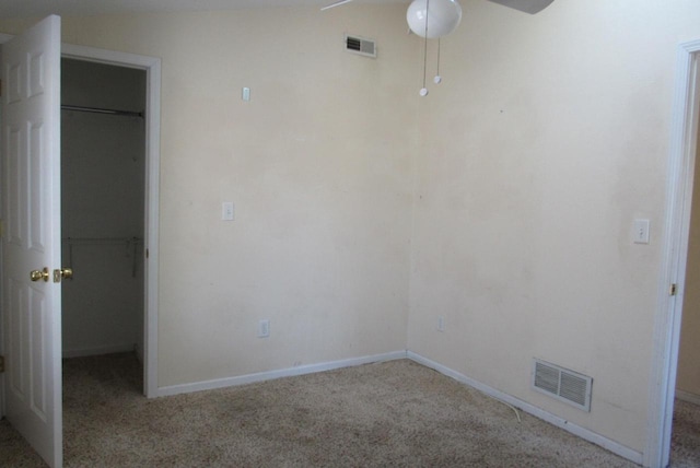 unfurnished bedroom featuring visible vents, a closet, and a walk in closet