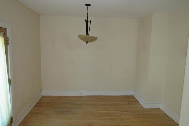 empty room with baseboards and light wood finished floors